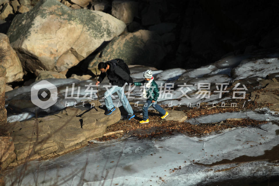 一位父亲带着儿子走在“固定的瀑布”上