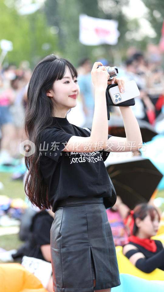 潍坊新青年音乐节上手持相机拍照的年轻女孩