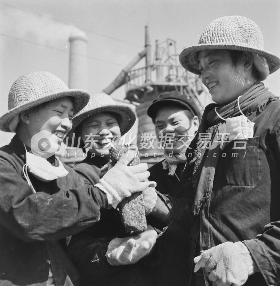 益都县第一钢铁厂妇女们炼出的铁块。