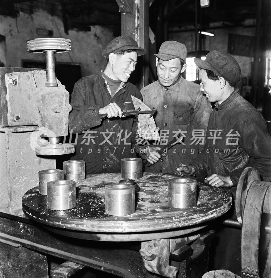 潍坊市建华机器厂技术员和工人一起研究安装圆盘铣床。